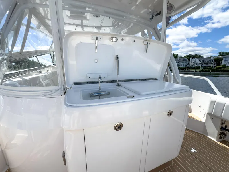 Slide: The Image of 2017 Intrepid 430 Sport Yacht with outdoor sink and storage, docked by the water. - 42