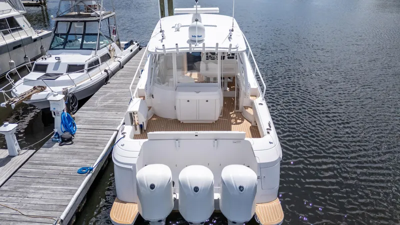 Slide: The Image of 2017 Intrepid 430 Sport Yacht docked, rear view with triple outboard engines. - 7