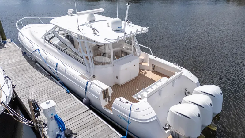 Slide: The Image of 2017 Intrepid 430 Sport Yacht docked, featuring triple outboard engines and sleek design. - 9