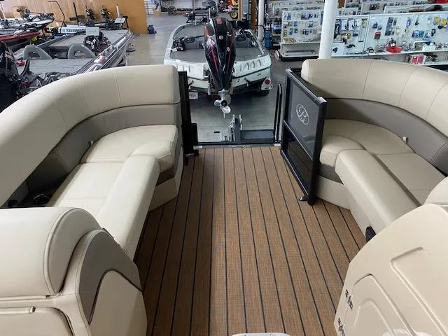 Slide: The Image of 2024 Bentley Pontoons 223 Elite Swing Back interior with beige seating and wood flooring. - 13