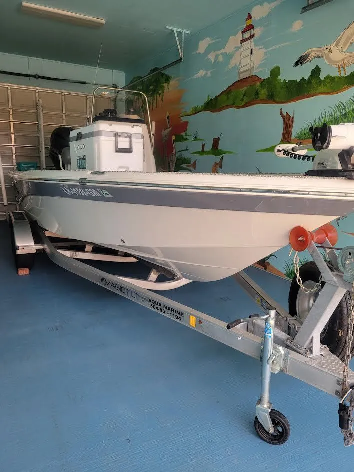 Slide: The Image of 2021 NauticStar 215 XTS boat on trailer in garage with mural background. - 2