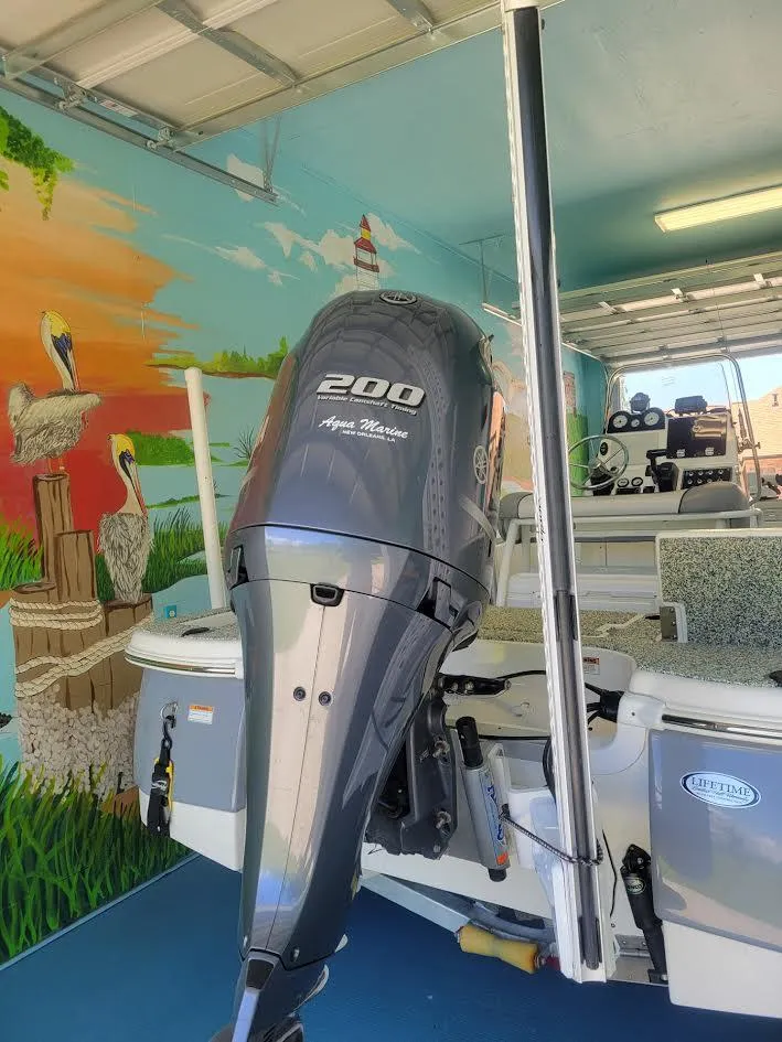 Slide: The Image of 2021 NauticStar 215 XTS boat with 200 HP engine in a vibrant mural-painted garage. - 3