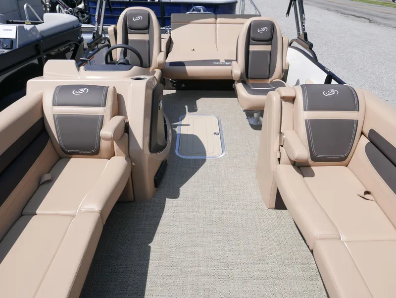 Slide: The Image of 2025 Barletta Cabrio 24UC pontoon boat interior with beige seating and steering console. - 9