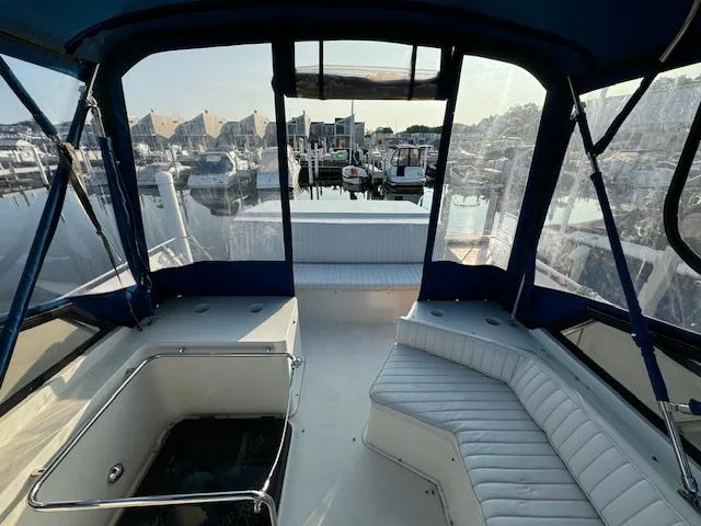 Slide: The Image of 1989 Carver 32 Mariner boat interior with seating, docked at marina. - 10