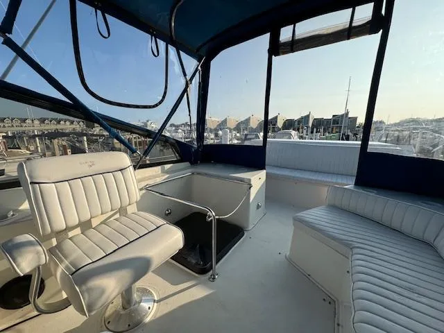 Slide: The Image of 1989 Carver 32 Mariner boat interior with white seating and marina view. - 11