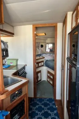 Slide: The Image of Interior of 1989 Carver 32 Mariner boat, featuring kitchen and cozy sleeping area. - 5