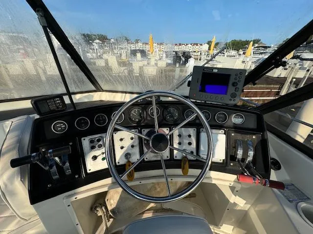 Slide: The Image of 1989 Carver 32 Mariner helm with steering wheel, gauges, and navigation equipment. - 9