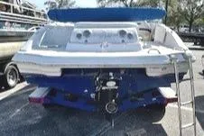 Slide: The Image of 2015 Tahoe 215 Xi boat, rear view with ladder, parked outdoors. - 3