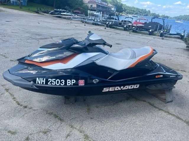 Slide: The Image of 2012 Sea-Doo GTI SE 155 jet ski parked near a lakeside marina. - 1