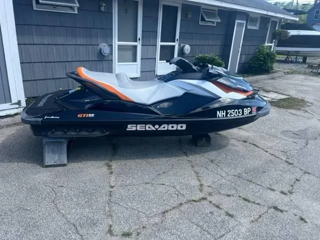 Slide: The Image of 2012 Sea-Doo GTI SE 155 jet ski parked on concrete driveway. - 2