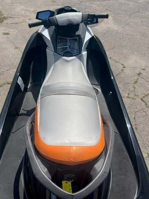 Slide: The Image of 2012 Sea-Doo GTI SE 155 jet ski with orange and gray seat, parked on pavement. - 6
