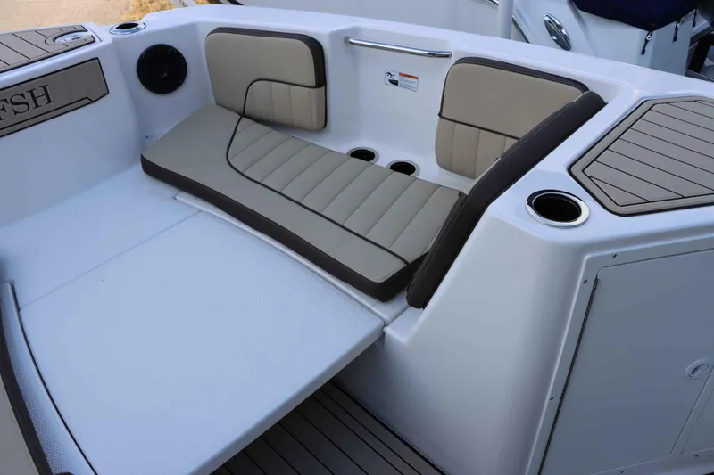 Slide: The Image of 2025 Yamaha Boats 222FSH SPORT E interior seating with cup holders and storage. - 13