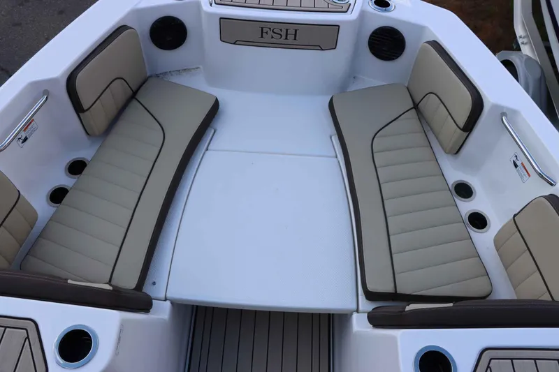 Slide: The Image of 2025 Yamaha Boats 222FSH SPORT E interior seating with beige cushions and cup holders. - 14