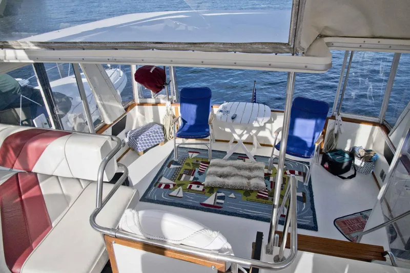 Slide: The Image of 1989 Sea Ray 440 Aft Cabin interior with seating, table, and nautical decor. - 18