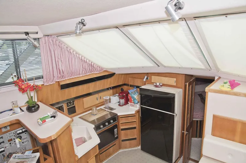 Slide: The Image of 1989 Sea Ray 440 Aft Cabin interior with kitchen, appliances, and floral decor. - 20