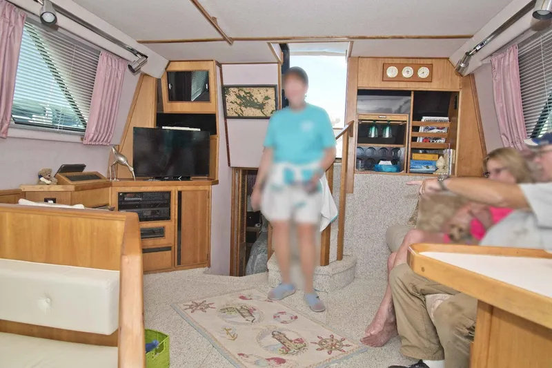 Slide: The Image of Interior of 1989 Sea Ray 440 Aft Cabin with people relaxing in cozy living area. - 22