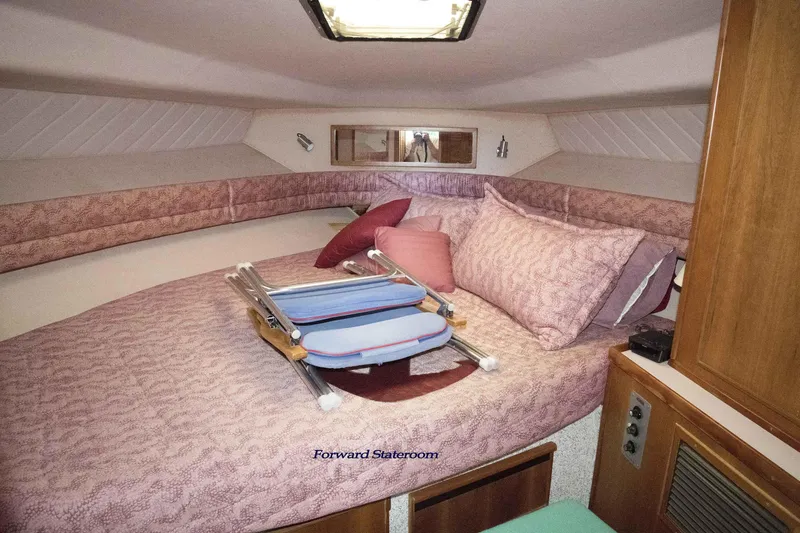Slide: The Image of Forward stateroom of 1989 Sea Ray 440 Aft Cabin with cozy bedding and storage. - 25
