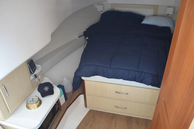 Slide: The Image of 2023 Regal 36 Grande Coupe cabin interior with bed, storage, and wooden flooring. - 19