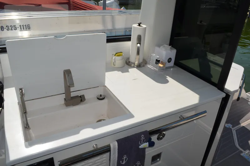 Slide: The Image of 2023 Regal 36 Grande Coupe yacht kitchenette with sink and countertop accessories. - 20