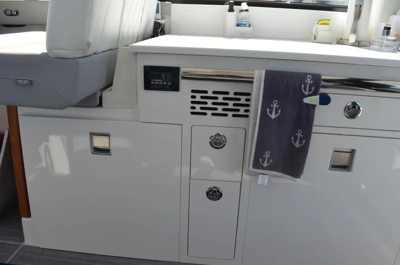 Slide: The Image of 2023 Regal 36 Grande Coupe interior with anchor-themed towel and modern cabinetry. - 23