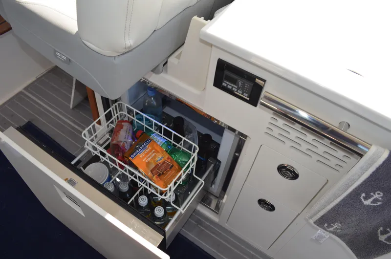 Slide: The Image of 2023 Regal 36 Grande Coupe interior with open drawer, showcasing snacks and beverages. - 24