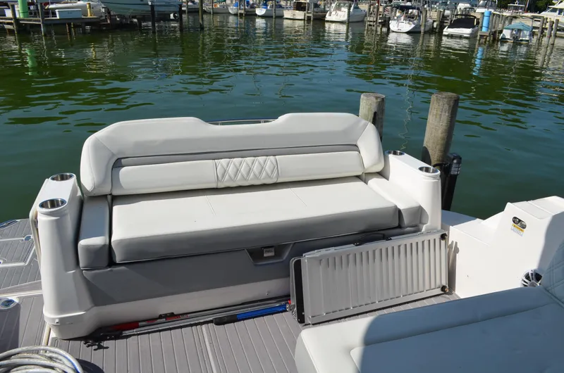 Slide: The Image of 2023 Regal 36 Grande Coupe boat seating area at a marina dock. - 9
