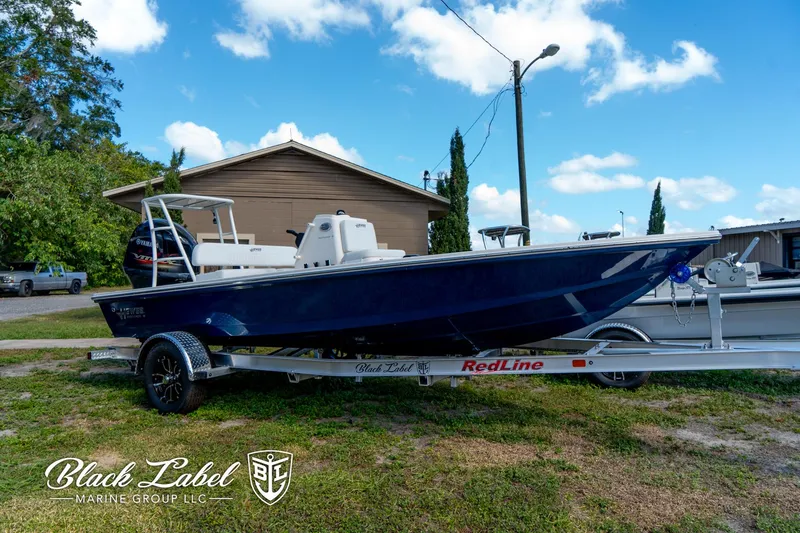Slide: The Image of 2025 Hewes 18 Redfisher boat on trailer, Black Label Marine Group branding. - 1