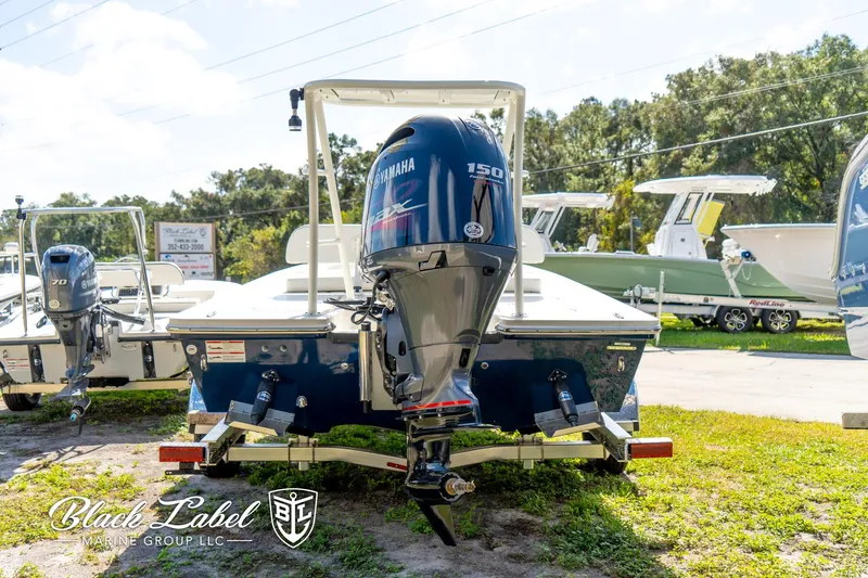 Slide: The Image of 2025 Hewes 18 Redfisher boat with Yamaha 150 engine, displayed outdoors. - 10