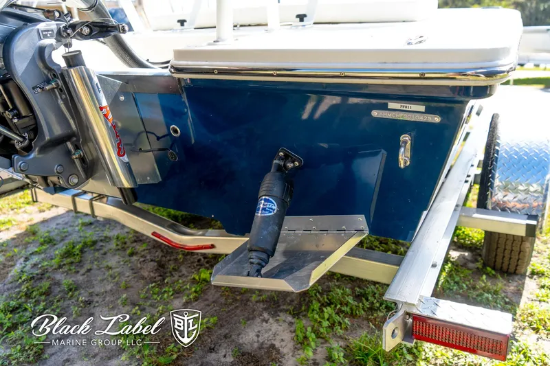 Slide: The Image of 2025 Hewes 18 Redfisher boat on trailer, rear view with motor and logo visible. - 12