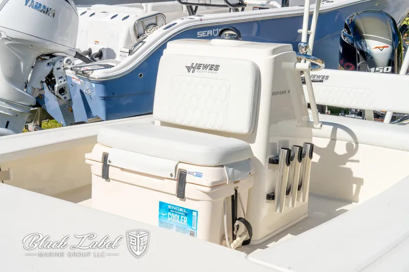 Slide: The Image of 2025 Hewes 18 Redfisher boat interior with seating and cooler, displayed at Black Label Marine Group. - 16