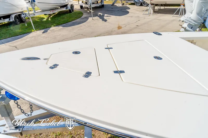 Slide: The Image of 2025 Hewes 18 Redfisher boat deck with storage compartments at a marina. - 17