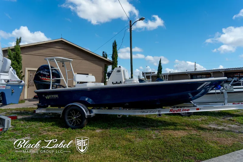 Slide: The Image of 2025 Hewes 18 Redfisher boat on trailer, displayed outdoors at Black Label Marine Group. - 2