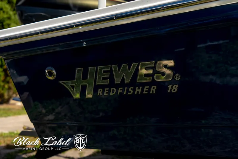 Slide: The Image of 2025 Hewes 18 Redfisher boat side view with logo and branding. - 3