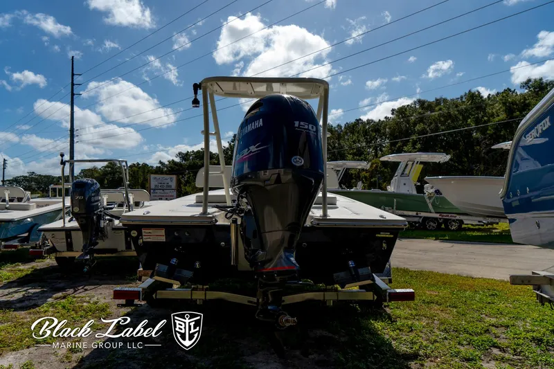 Slide: The Image of 2025 Hewes 18 Redfisher boat with Yamaha 150 engine, displayed outdoors at Black Label Marine. - 7