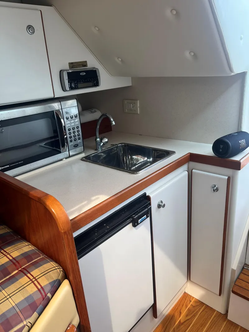 Slide: The Image of 2004 Tiara Yachts 2900 Coronet interior with white seating and wood flooring. - 15