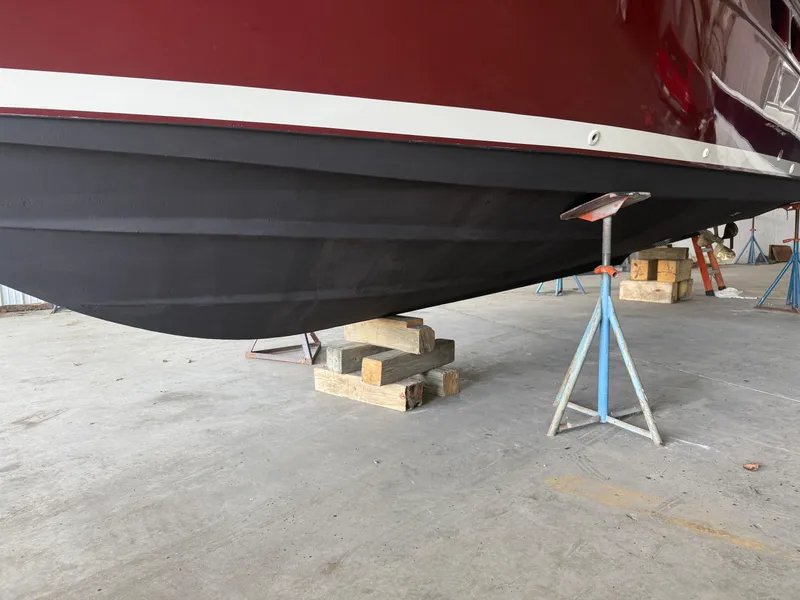 Slide: The Image of 2004 Tiara Yachts 2900 Coronet underside with propeller and ladder in a workshop setting. - 5