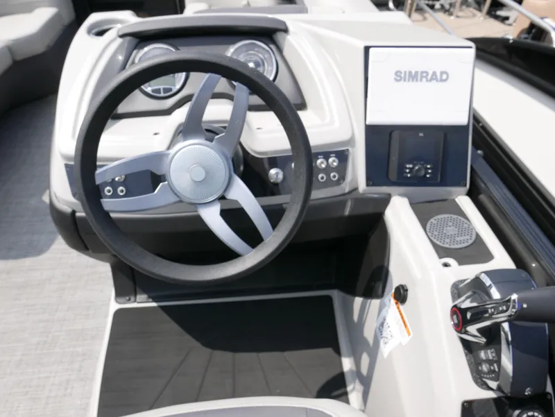 Slide: The Image of 2025 Barletta Cabrio 24UE boat dashboard with steering wheel and Simrad display. - 20