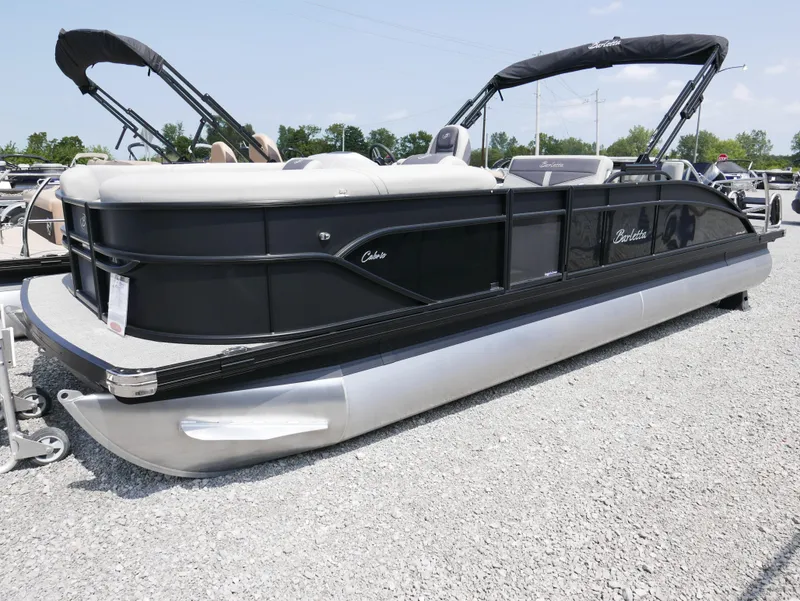 Slide: The Image of 2025 Barletta Cabrio 24UE pontoon boat on gravel lot, black and silver design. - 3