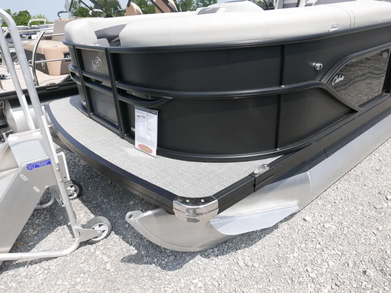 Slide: The Image of 2025 Barletta Cabrio 24UE pontoon boat, sleek black design on gravel surface. - 4
