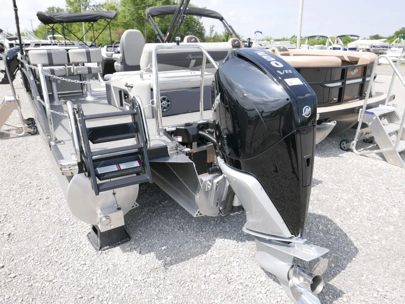 Slide: The Image of 2025 Barletta Cabrio 24UE pontoon boat with powerful outboard motor, parked on gravel. - 5