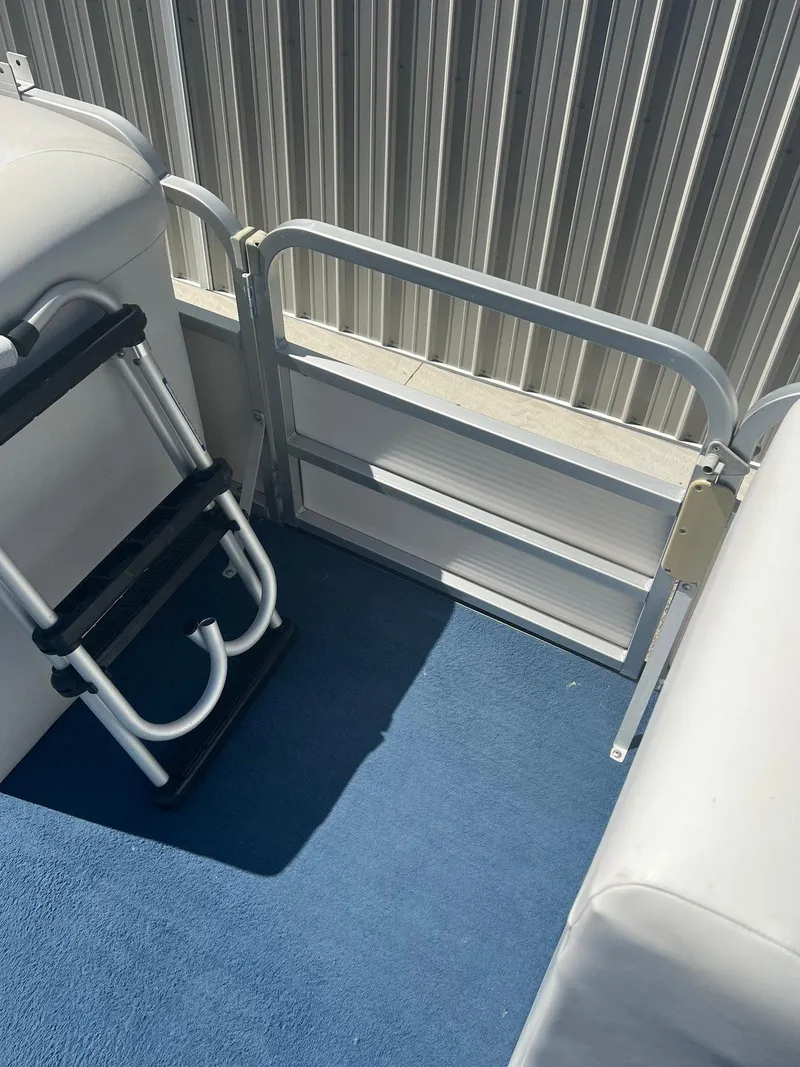 Slide: The Image of 2003 Sylvan Mirage boat interior with blue carpet and foldable ladder. - 1