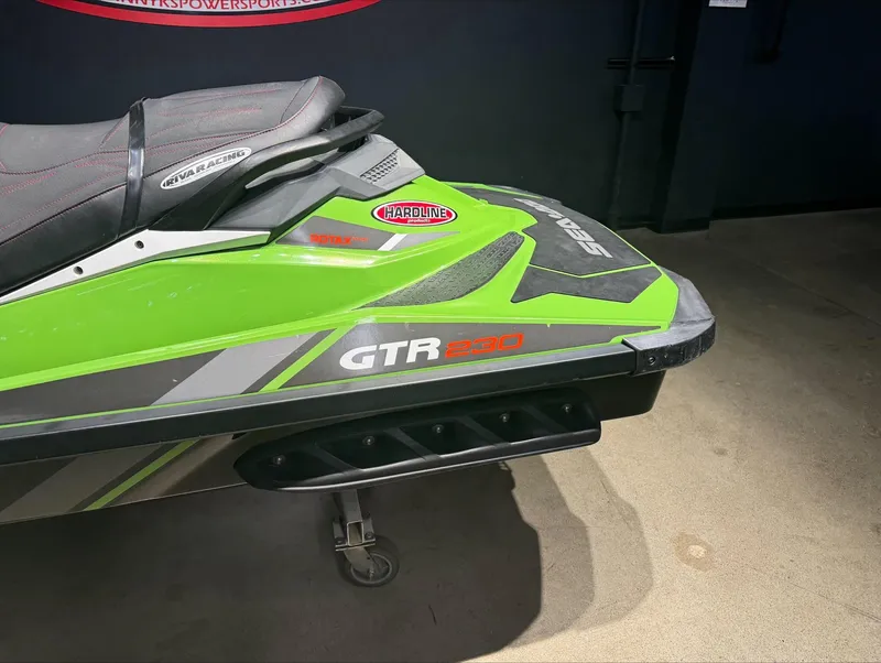 Slide: The Image of 2017 Sea-Doo GTR-X 230, green and black jet ski, side view. - 2