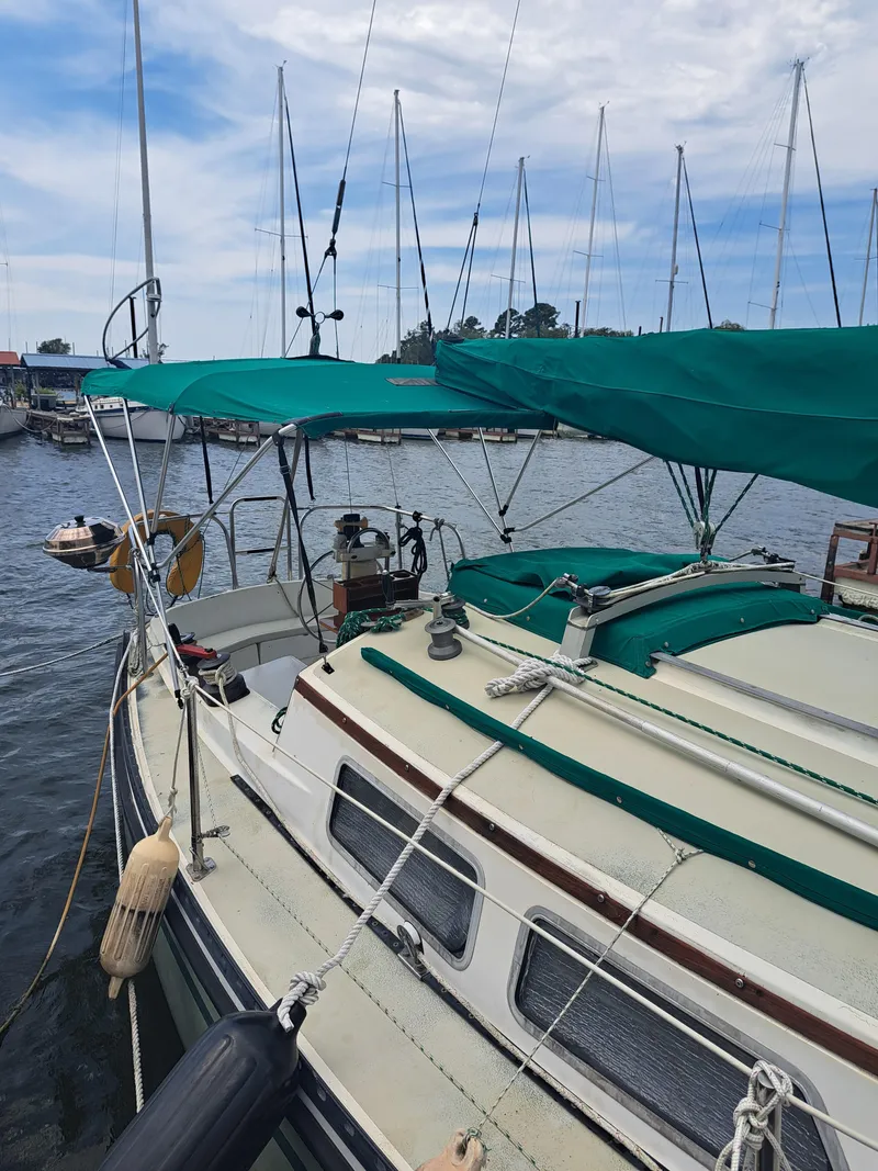 Slide: The Image of 1979 Newport Mark II sailboat docked in a marina with green canopy. - 10