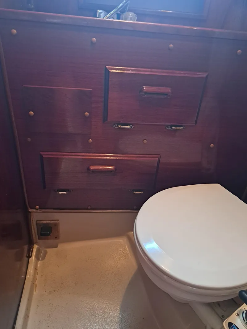 Slide: The Image of 1979 Newport Mark II boat bathroom with wooden cabinetry and white toilet. - 19