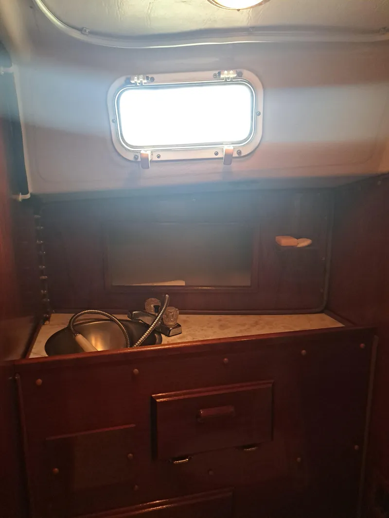 Slide: The Image of 1979 Newport Mark II yacht interior with wooden cabinetry and porthole window. - 20