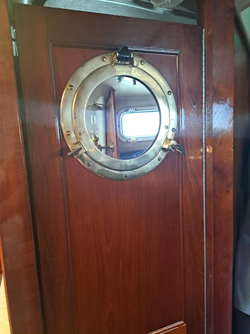 Slide: The Image of Wooden door with brass porthole on 1979 Newport Mark II boat. - 21