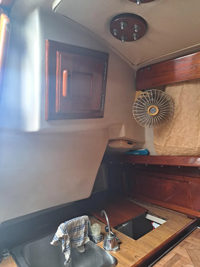 Slide: The Image of 1979 Newport Mark II boat interior with wooden cabinets and sink. - 25