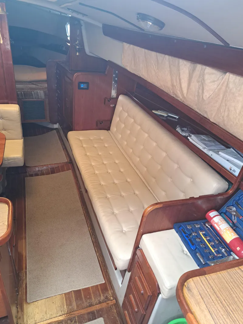 Slide: The Image of Interior of a 1979 Newport Mark II sailboat with beige seating and wooden accents. - 27