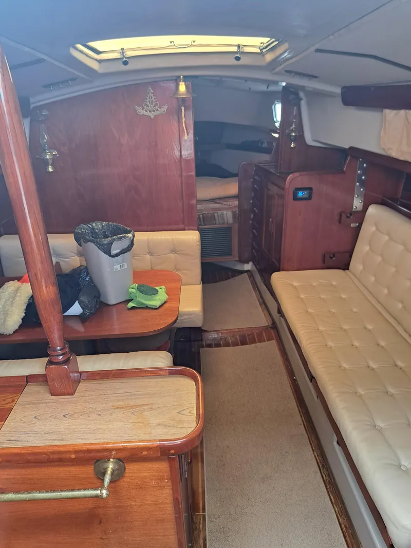 Slide: The Image of Interior of a 1979 Newport Mark II sailboat with wood paneling and cushioned seating. - 28