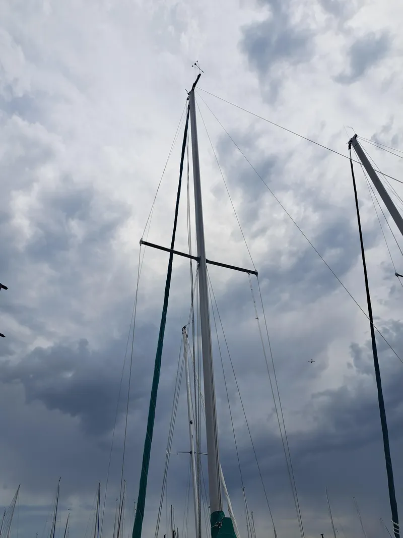 Slide: The Image of Tall mast of a 1979 Newport Mark II sailboat against a cloudy sky. - 4